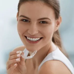 Startzville woman holding clear braces from canyon lake dentist